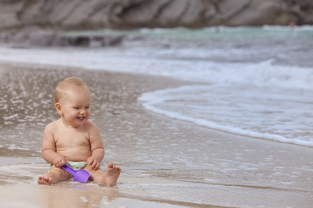 bebé jugando en la orilla de la playa