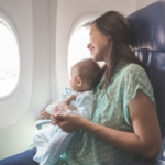 Madre viajando en avión con su bebé