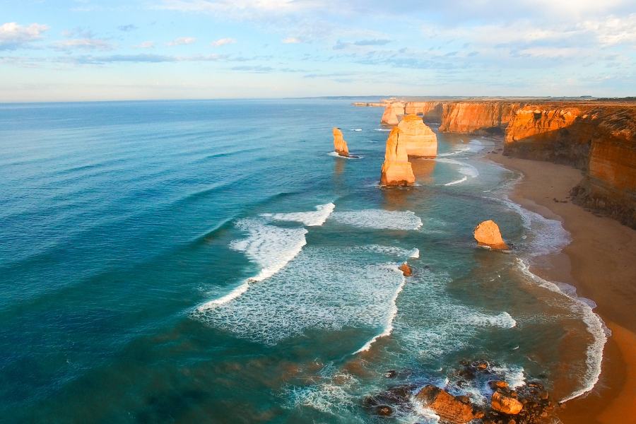 Los 12 apóstoles, en el Parque Nacional Port Campbell, Australia vistos desde el aire con las olas rompiendo en la orilla y un cielo azul despejado