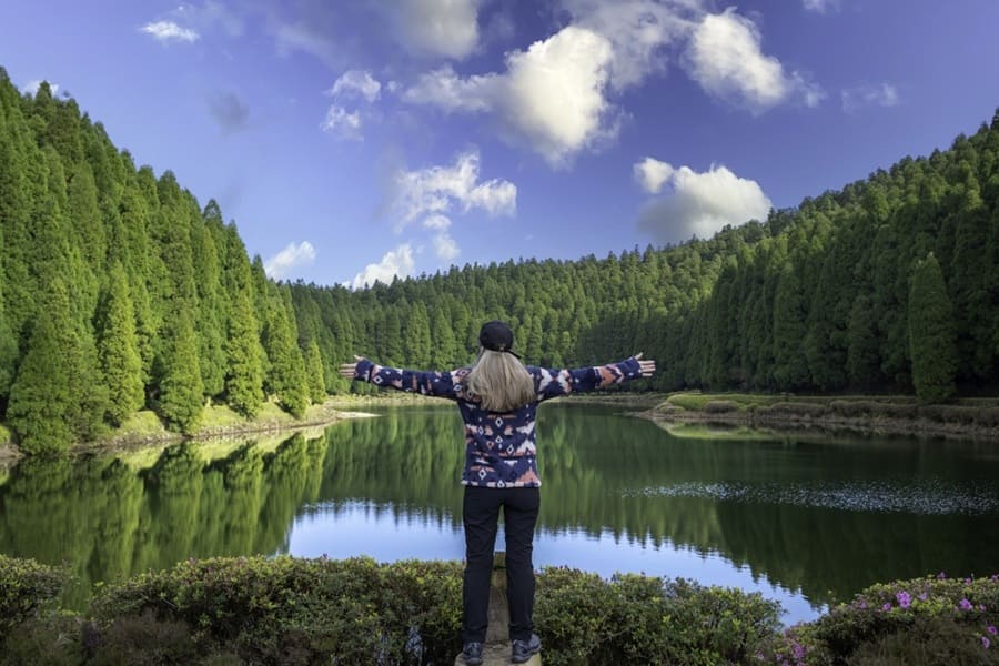 Mujer con los brazos abiertos en el Lagoa das Empadadas, Sete Cidades, Isla de São Miguel, Azores