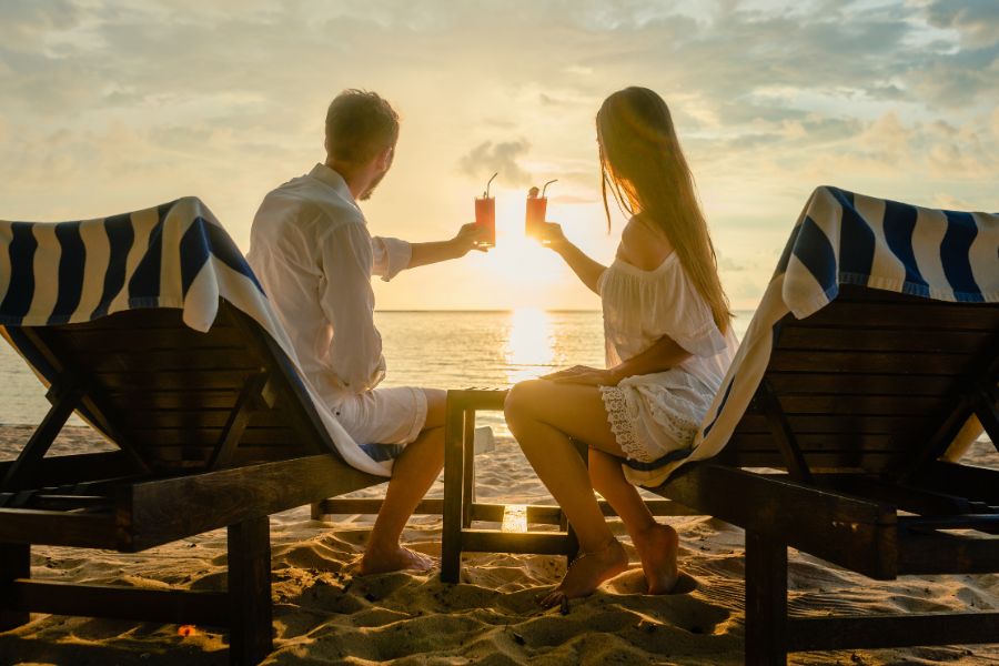 Pareja tomando un cocktail junto al mar