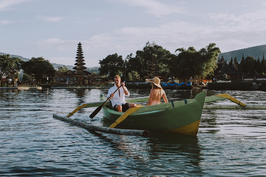 Pareja en un bote de madera en Pura Ulun Danu Bratan, Bali