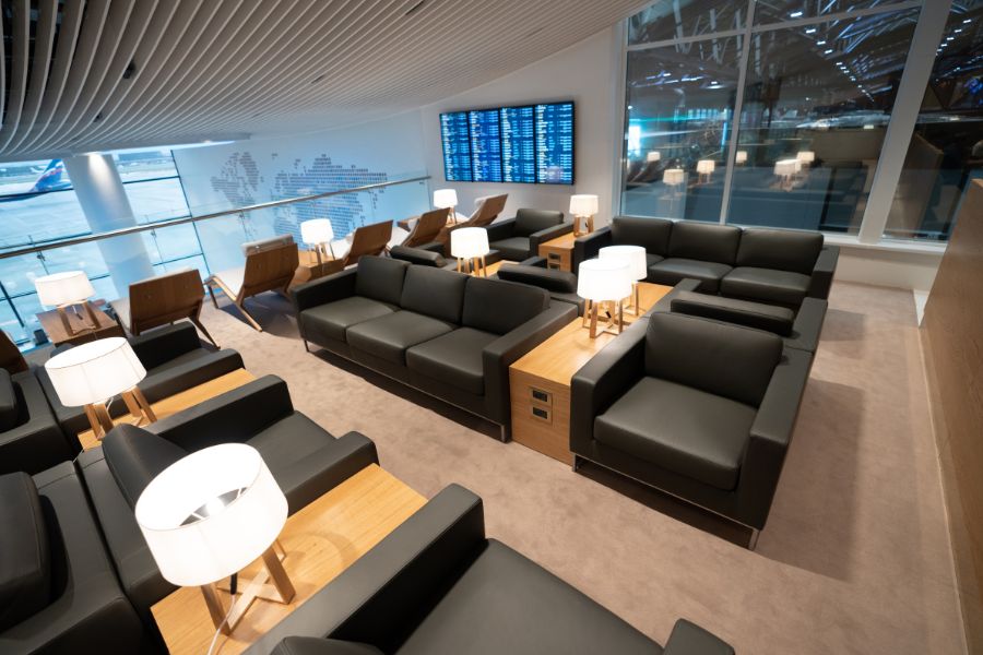 salon VIP lounge aeropuerto con sofás lámparas y espacio para descansar