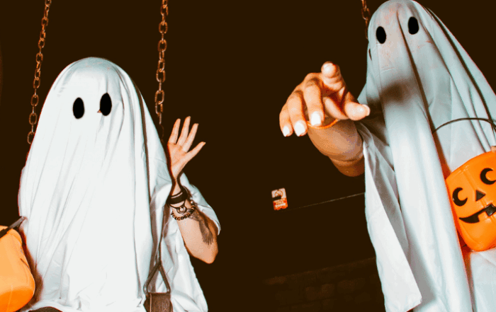 dos fantasmas de halloween sujetando calabazas