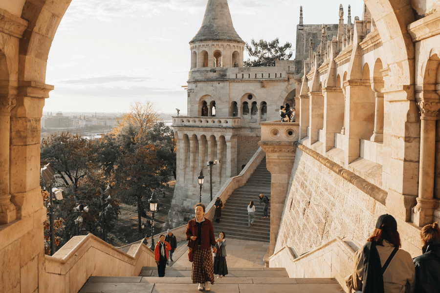 Turistas bajan por las escaleras de piedra del castillo de Budapest observando la ciudad
